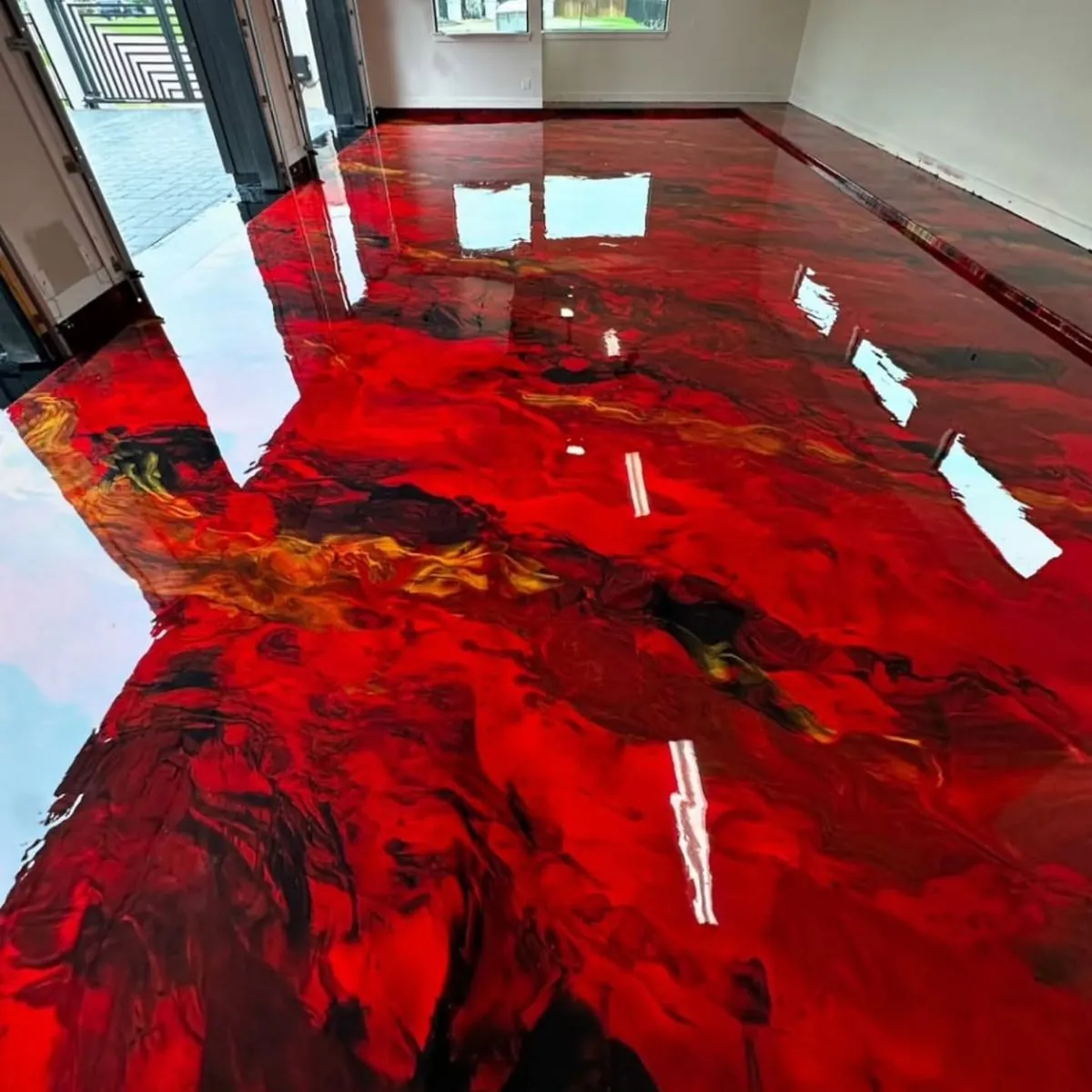 Garage con piso epóxico metálico rojo con vetas negras y doradas